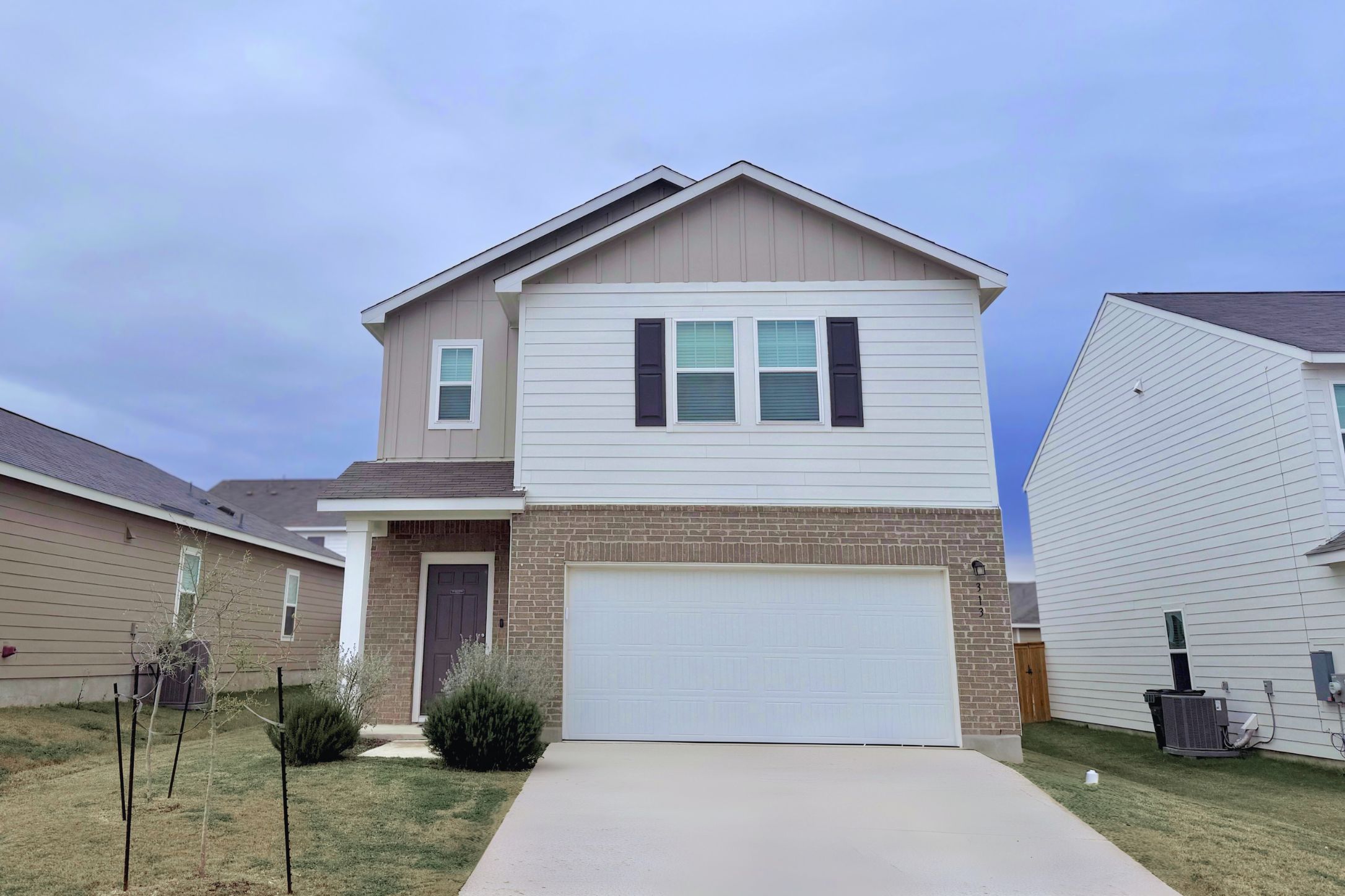 313 Magnum Force Drive Jarrell, TX 76537 - Photo 1 of 27 View of front of property featuring board and batten siding, brick siding, concrete driveway, and 2 Car garage