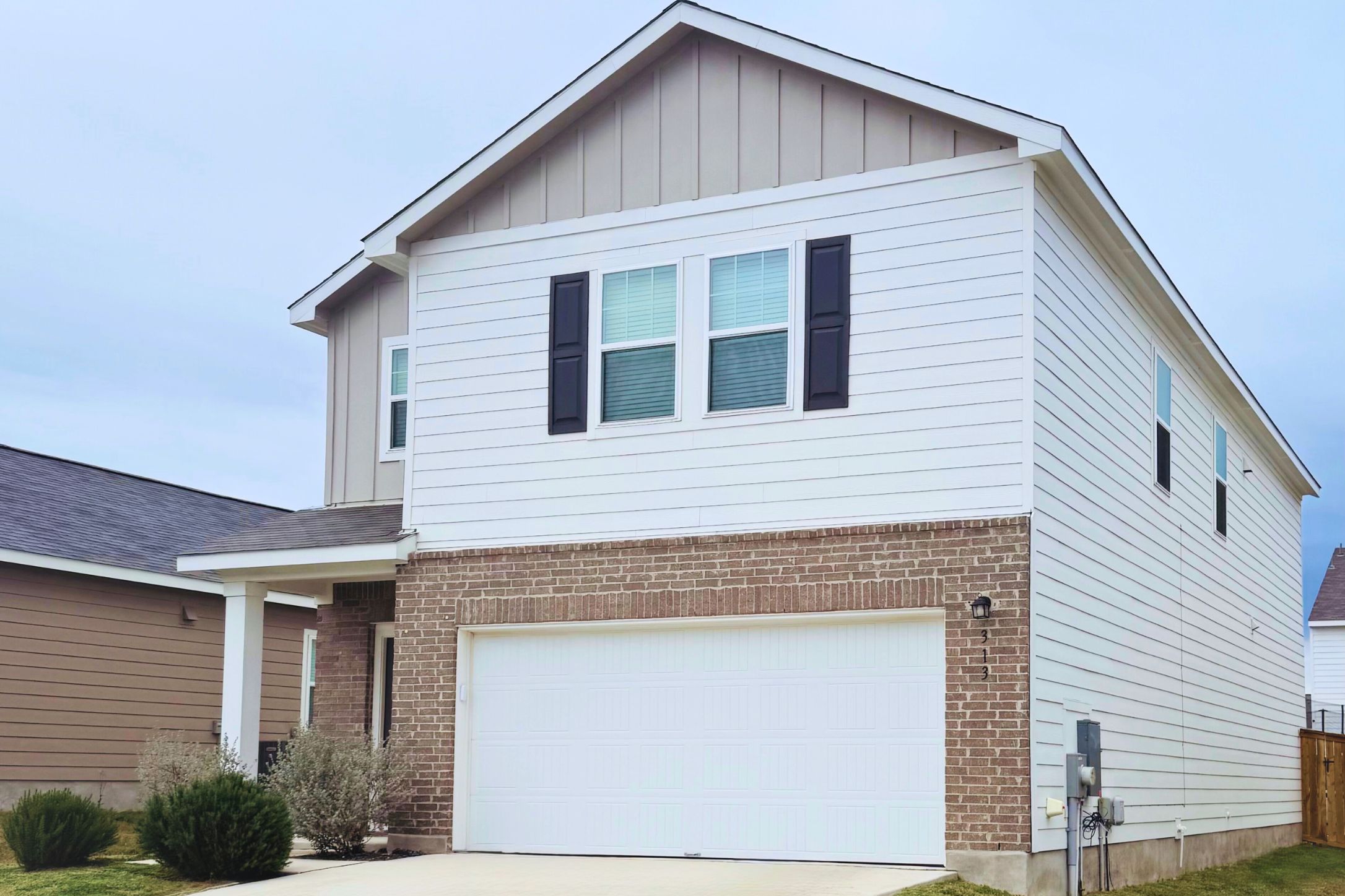 313 Magnum Force Drive Jarrell, TX 76537 - Photo 2 of 27 View of front of house featuring brick siding, board and batten siding, a garage, and concrete driveway