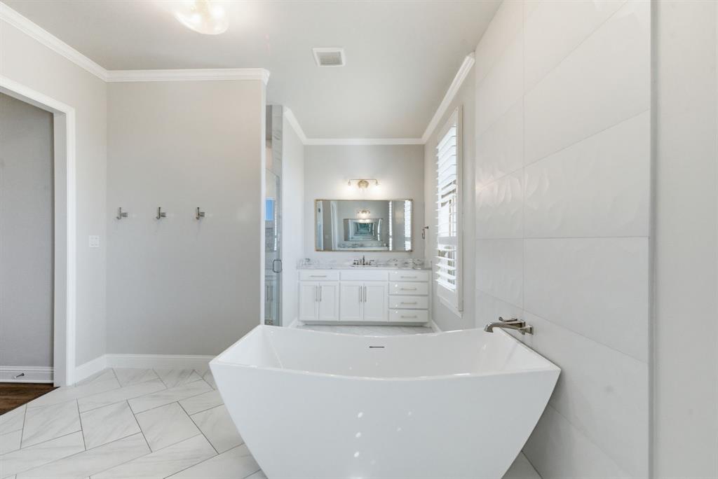 4600 Old Brock Road Weatherford, TX 76087 - Photo 22 of 40 Full bathroom with vanity, a freestanding tub, light marble finish floors, ornamental molding, and a stall shower