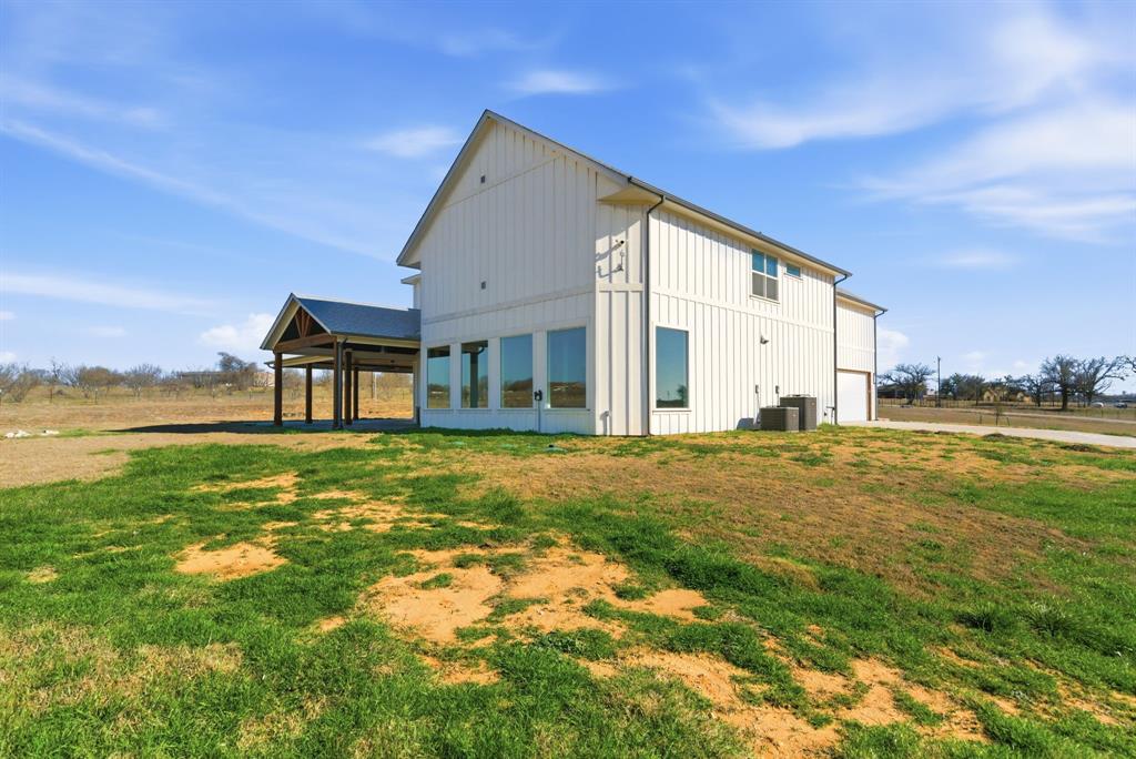 4600 Old Brock Road Weatherford, TX 76087 - Photo 38 of 40 Rear view of property featuring board and batten siding, a yard, and a patio