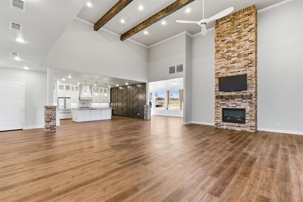 4600 Old Brock Road Weatherford, TX 76087 - Photo 6 of 40 Unfurnished living room with a fireplace, ceiling fan, dark wood-type flooring, ornamental molding, and recessed lighting