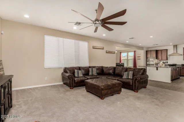 a kitchen with stainless steel appliances granite countertop a refrigerator a stove a sink a dining table and chairs