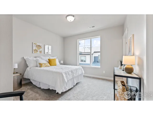 a living room with a bed furniture and next to a window
