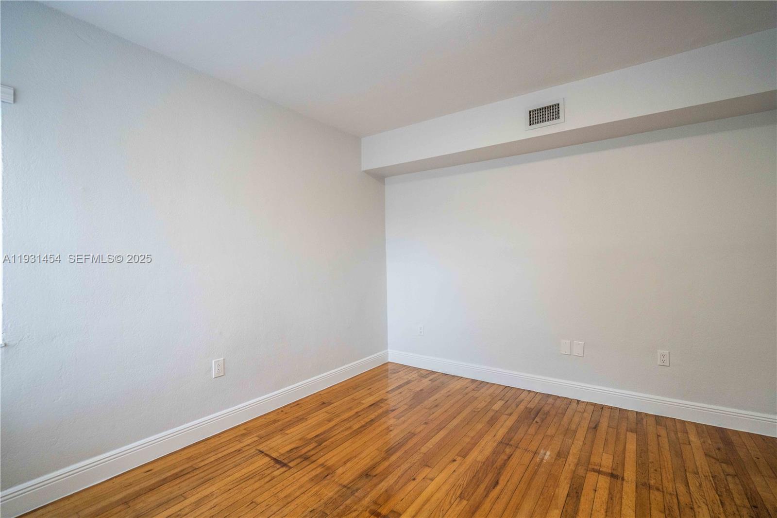 1007 Bay Drive, Unit 205 Miami Beach, FL 33141 - Photo 12 of 17 a view of an empty room with wooden floor