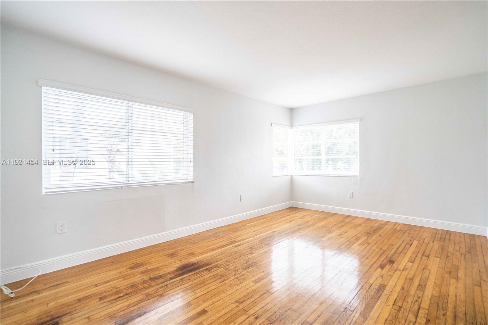 1007 Bay Drive, Unit 205 Miami Beach, FL 33141 - Photo 2 of 17 a view of an empty room with wooden floor and a window