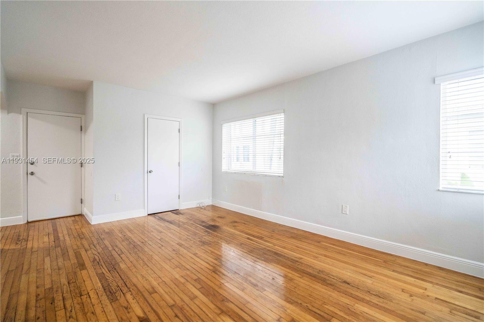 1007 Bay Drive, Unit 205 Miami Beach, FL 33141 - Photo 3 of 17 a view of an empty room with wooden floor and a window