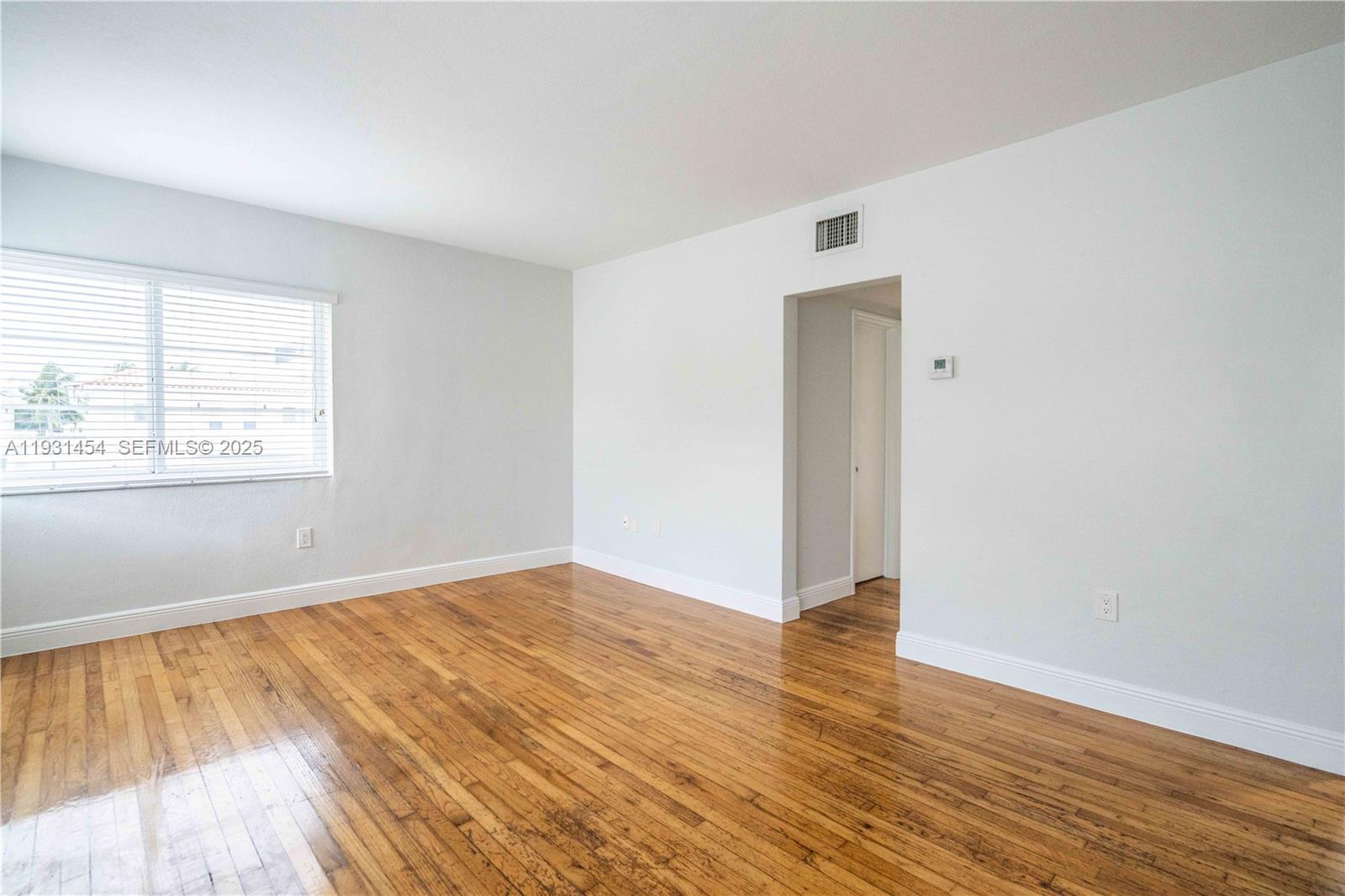 1007 Bay Drive, Unit 205 Miami Beach, FL 33141 - Photo 5 of 17 an empty room with wooden floor and windows