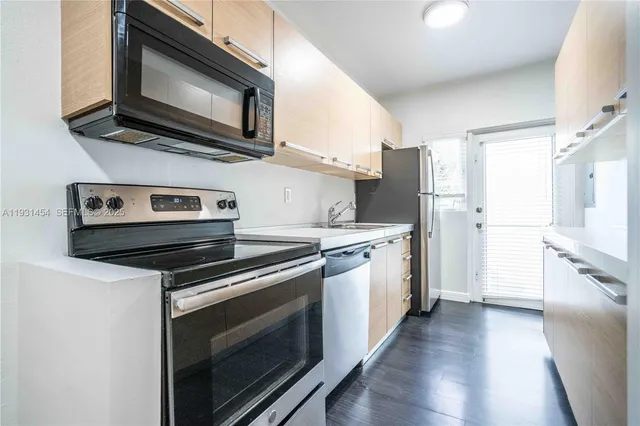 a kitchen with stainless steel appliances a stove microwave and refrigerator