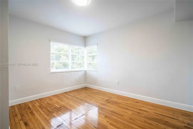 a view of a room with wooden floor and natural light