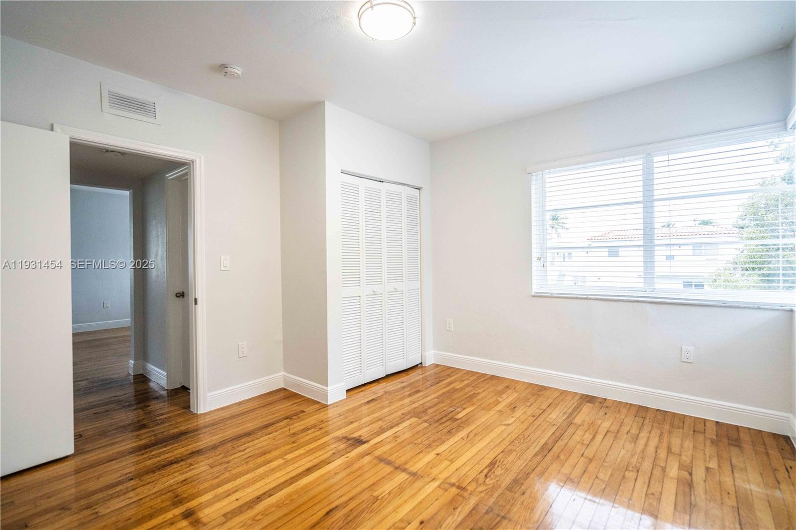 1007 Bay Drive, Unit 205 Miami Beach, FL 33141 - Photo 10 of 17 a view of an empty room with wooden floor and a window