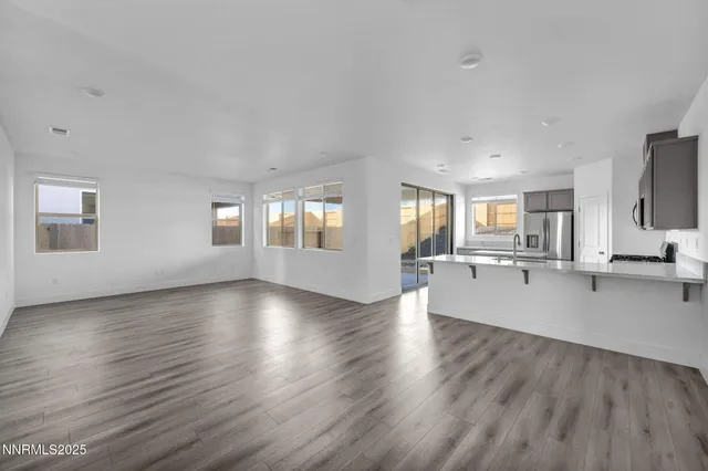 a view of a big room with wooden floor and windows