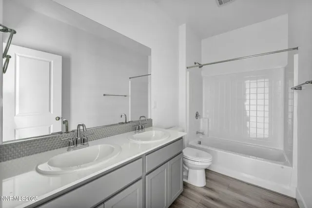 a bathroom with a granite countertop sink toilet a large mirror and shower