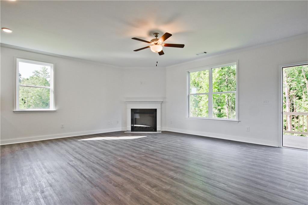 5985 Spring Way Lithonia, GA 30058 - Photo 8 of 34 an empty room with wooden floor chandelier fan and windows
