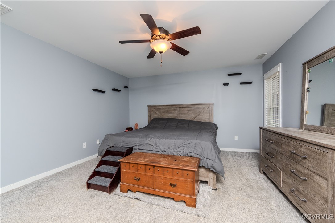 1990 Walnut Tree Road Powhatan, VA 23139 - Photo 15 of 40 a bedroom with a bed and a ceiling fan