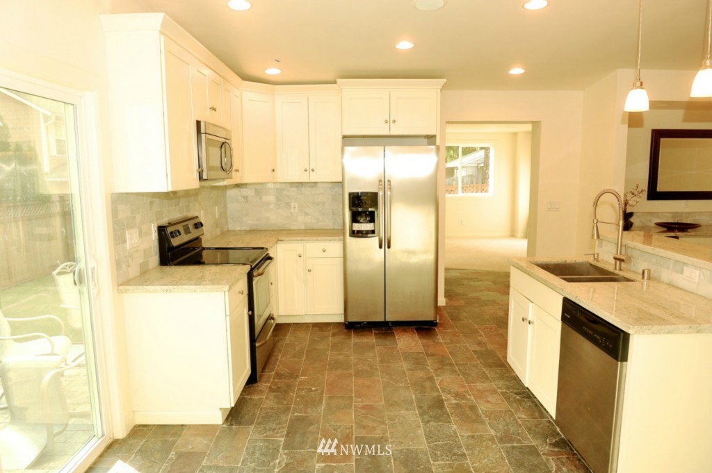 14205 Southeast Allen Rd. Bellevue, WA 98006 - Photo 4 of 15 a kitchen with a refrigerator a sink and a stove