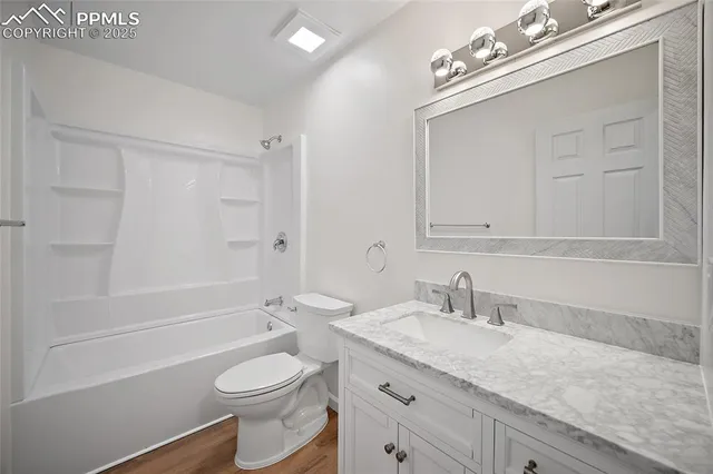 a bathroom with a granite countertop sink a toilet and shower