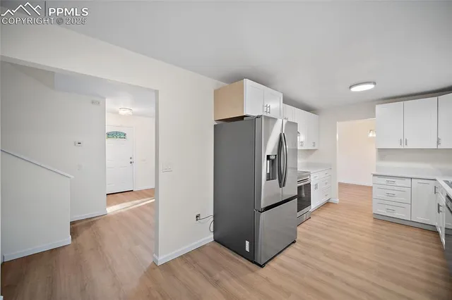 a kitchen with a refrigerator and a stove top oven