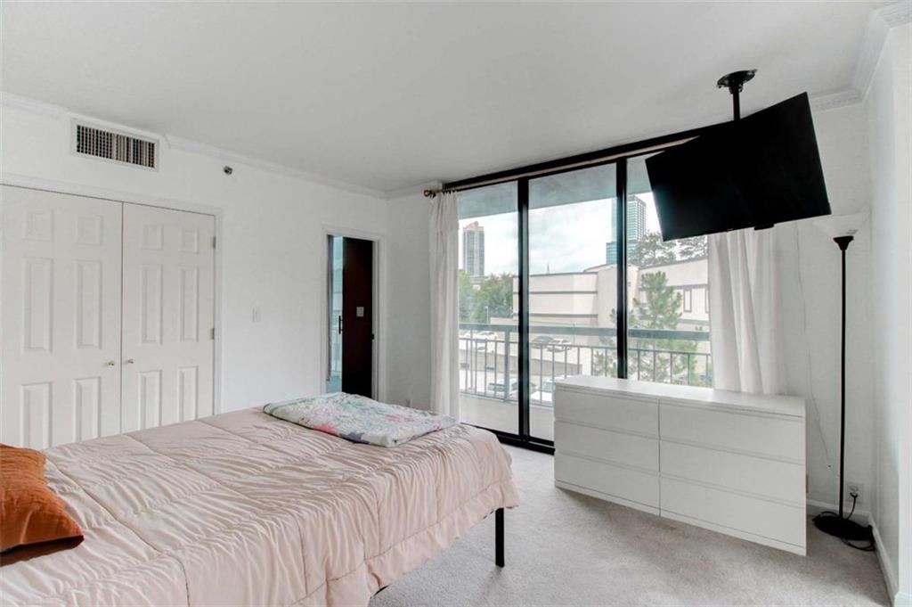 3481 Lakeside Drive Northeast, Unit 902 Atlanta, GA 30326 - Photo 15 of 43 a bedroom with a large bed and a flat tv screen
