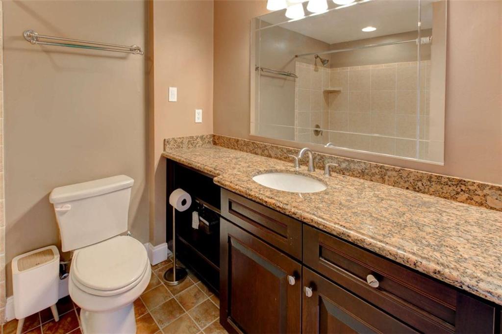 3481 Lakeside Drive Northeast, Unit 902 Atlanta, GA 30326 - Photo 18 of 43 a bathroom with a granite countertop toilet sink and mirror