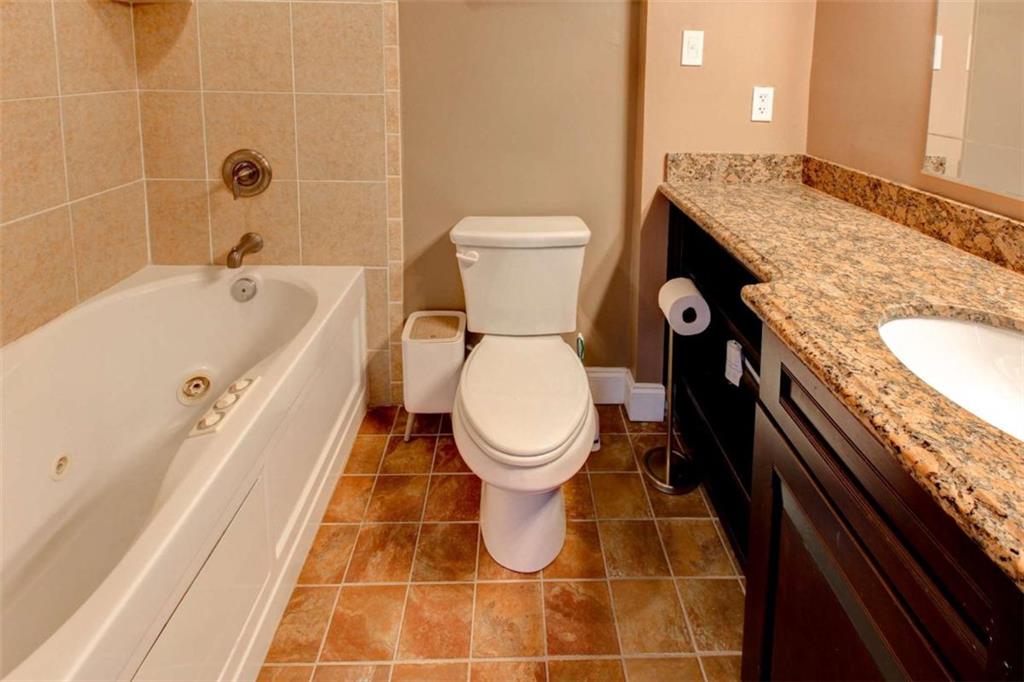 3481 Lakeside Drive Northeast, Unit 902 Atlanta, GA 30326 - Photo 20 of 43 a bathroom with a granite countertop toilet and a sink