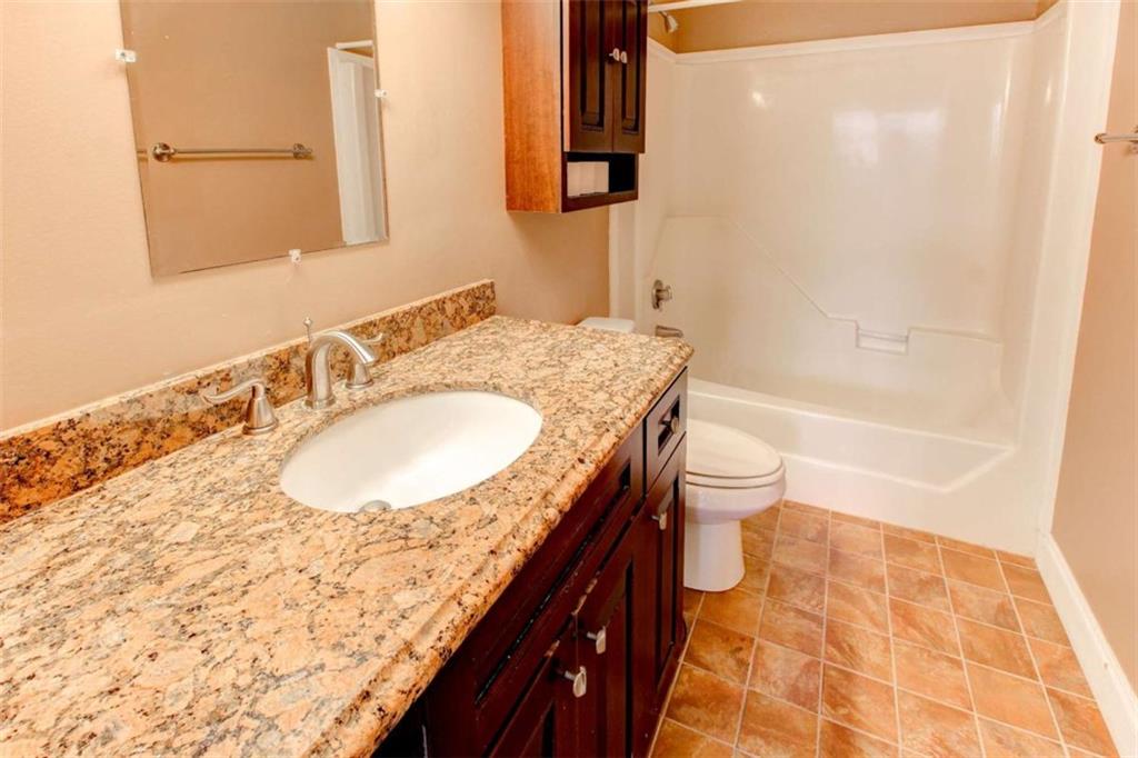 3481 Lakeside Drive Northeast, Unit 902 Atlanta, GA 30326 - Photo 28 of 43 a bathroom with a granite countertop sink toilet and shower