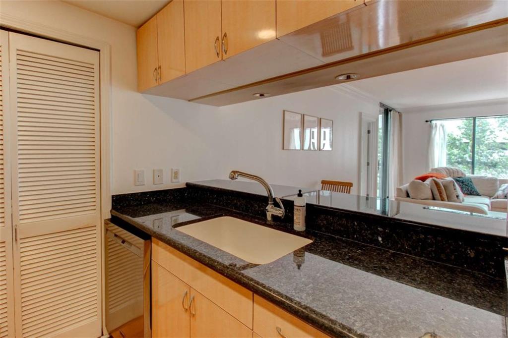 3481 Lakeside Drive Northeast, Unit 902 Atlanta, GA 30326 - Photo 4 of 43 a bathroom with a granite countertop sink a toilet and mirror