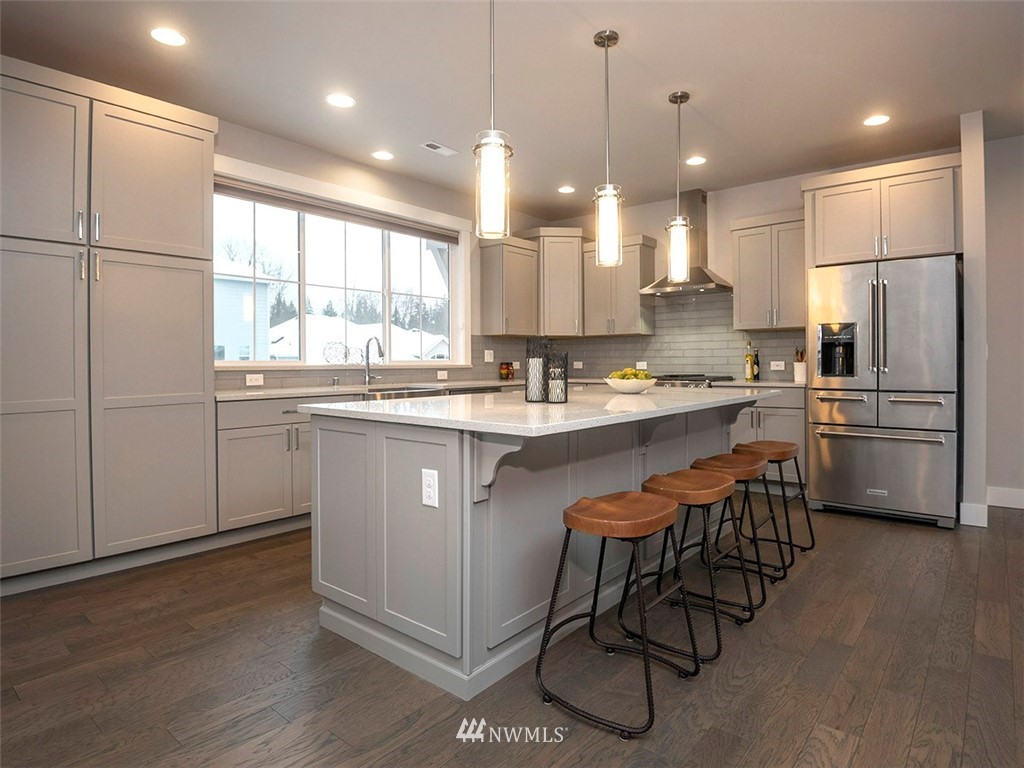 17 197th Place Southwest Bothell, WA 98012 - Photo 8 of 34 a kitchen with stainless steel appliances granite countertop a sink a stove a refrigerator and island with wooden floor