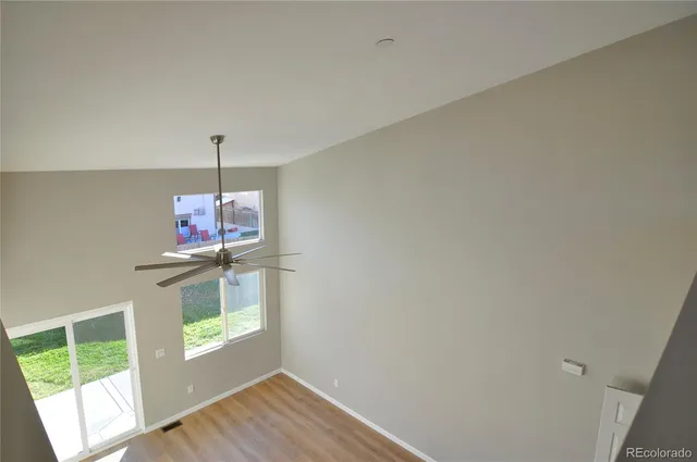 an empty room with a window and a fan