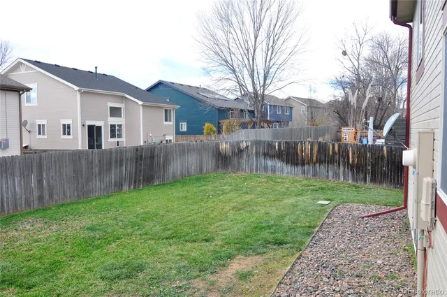 a view of an house with backyard and a tree