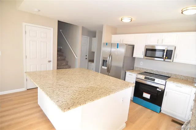 a kitchen with stainless steel appliances granite countertop a refrigerator stove top oven and sink