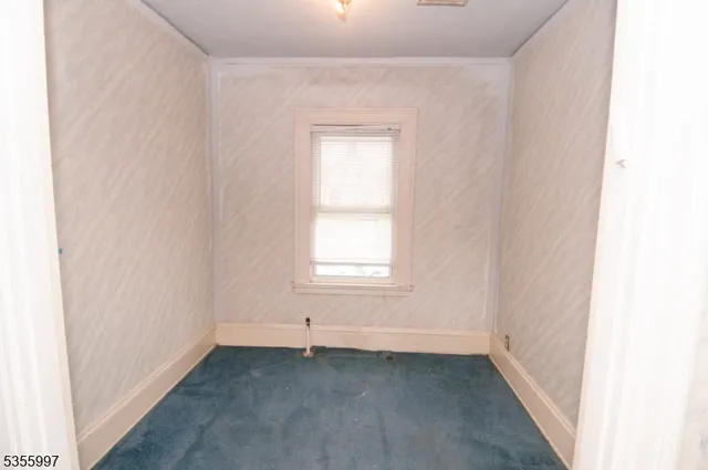 a view of a small space with wooden floor and a window