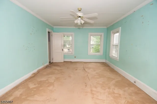 an empty room with fan and windows