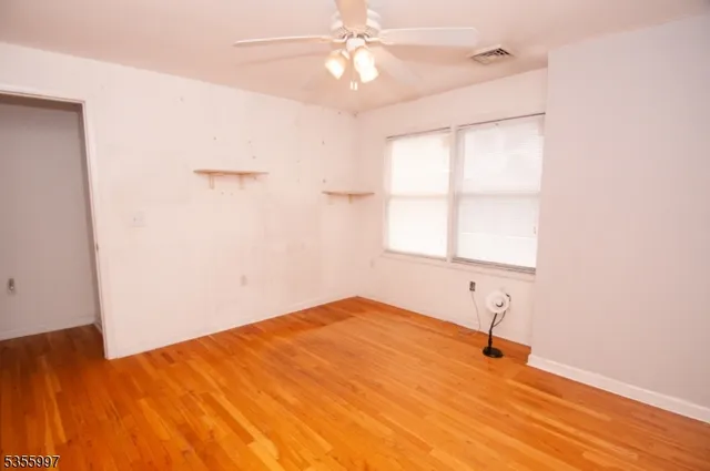 a view of a room with a window and wooden floor