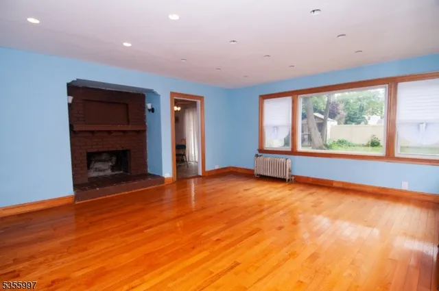 a view of an empty room with a fireplace and a window