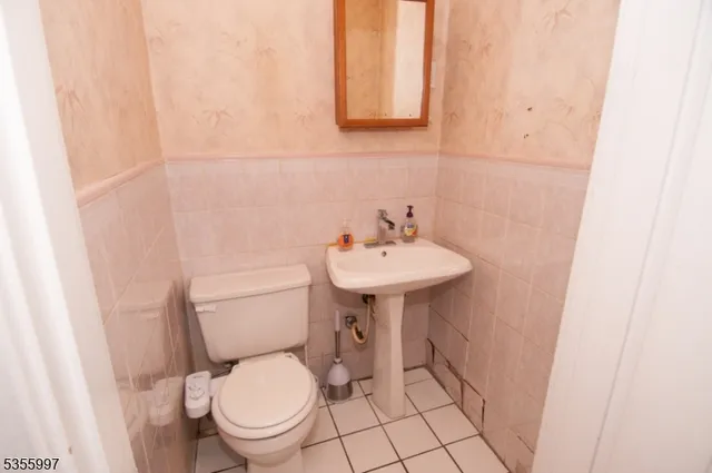 a bathroom with a sink a toilet and a mirror