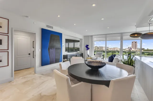 a living room with furniture a table and kitchen view
