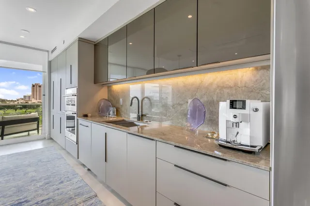 a kitchen with granite countertop a sink a white cabinets and a stove