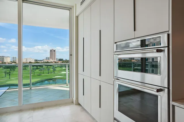 a large kitchen with stainless steel appliances kitchen island granite countertop a sink and white cabinets