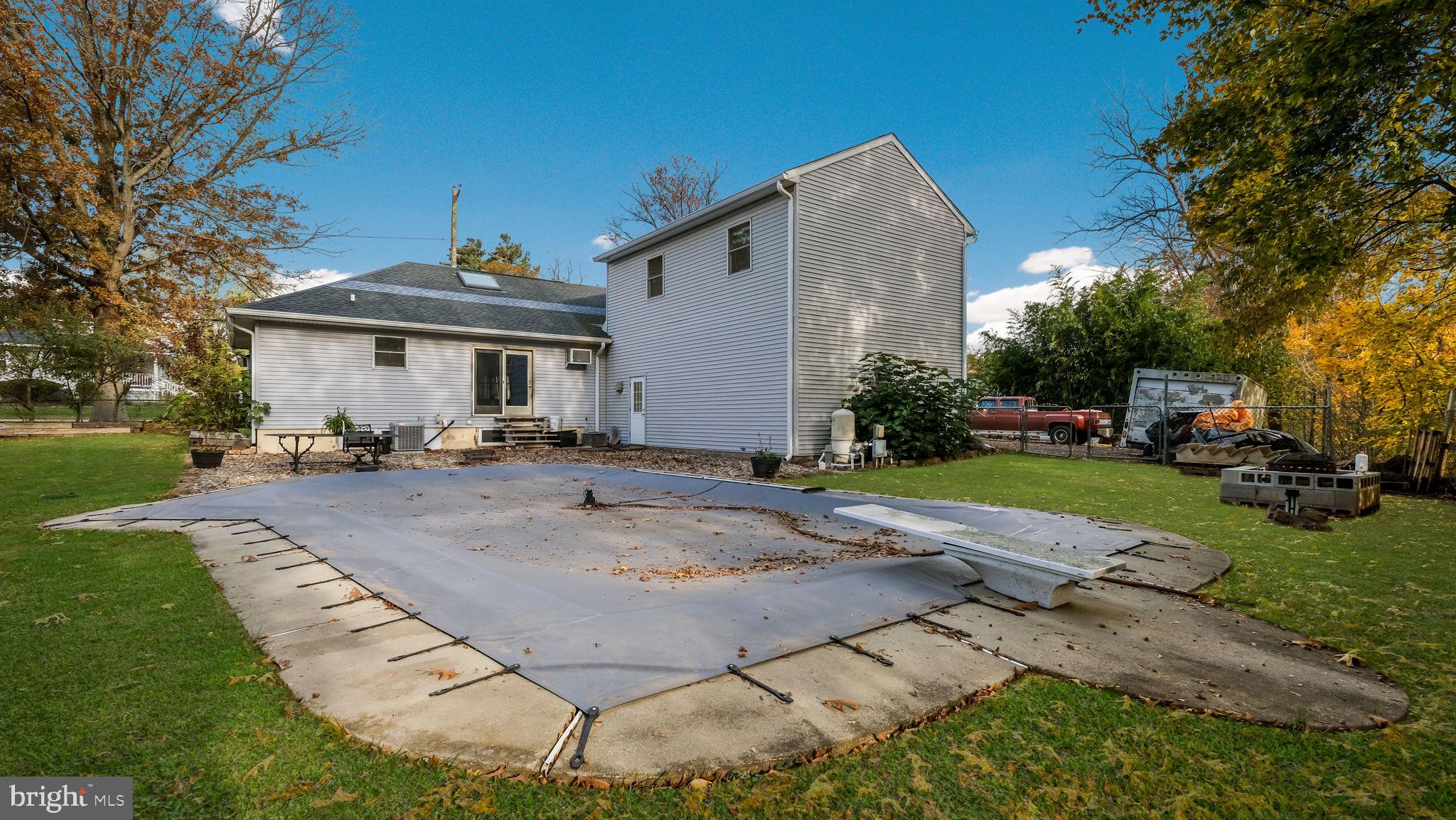 2943 East Walnut Street Colmar, PA 18915 - Photo 26 of 27 a view of a white house with a yard patio and fire pit