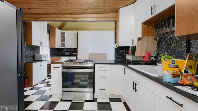 a kitchen with a sink a stove and cabinets