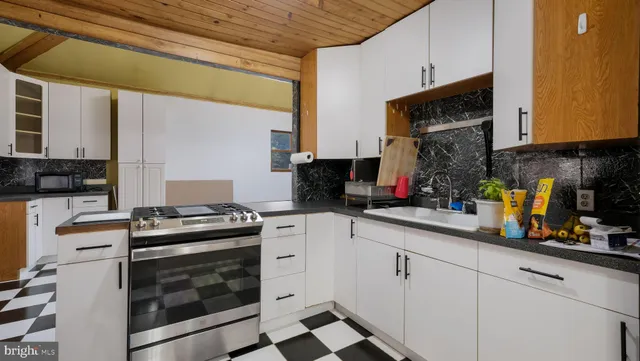 a kitchen with stainless steel appliances a stove a sink and a microwave