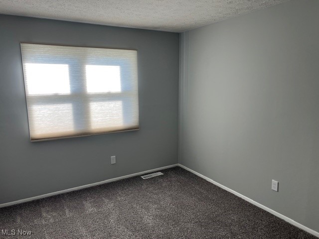 2276 Raber Road, Unit C Uniontown, OH 44685 - Photo 11 of 13 Empty room featuring dark colored carpet and a textured ceiling