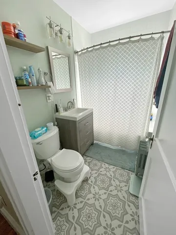 a white toilet sitting next to a bathroom sink and a shower