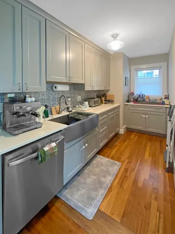 a kitchen with stainless steel appliances granite countertop a sink counter space cabinets and a large window