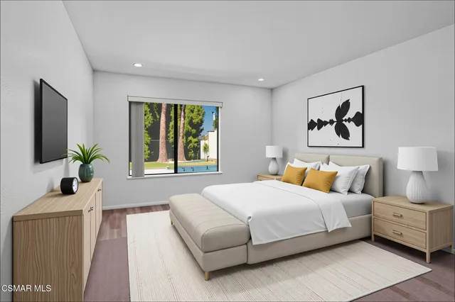 a bedroom with a large bed and a potted plant