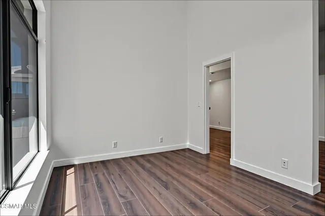 an empty room with wooden floor and entrance