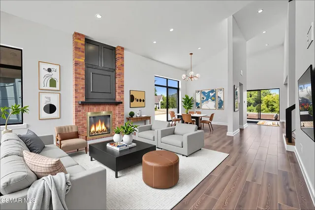 a living room with fireplace furniture and a large window