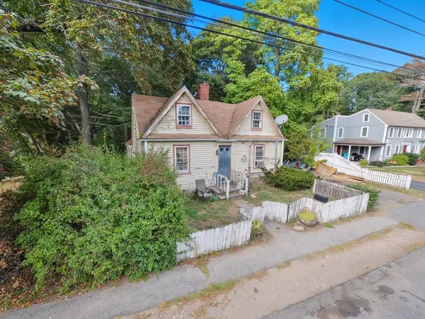 a front view of a house with a yard and potted plants