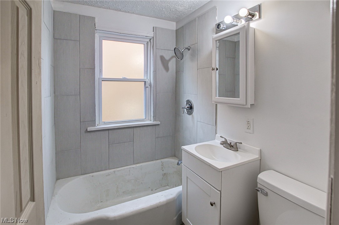 3423 Westbury Road Cleveland, OH 44120 - Photo 35 of 38 Full bathroom featuring a textured ceiling, tiled shower / bath, large vanity, and toilet