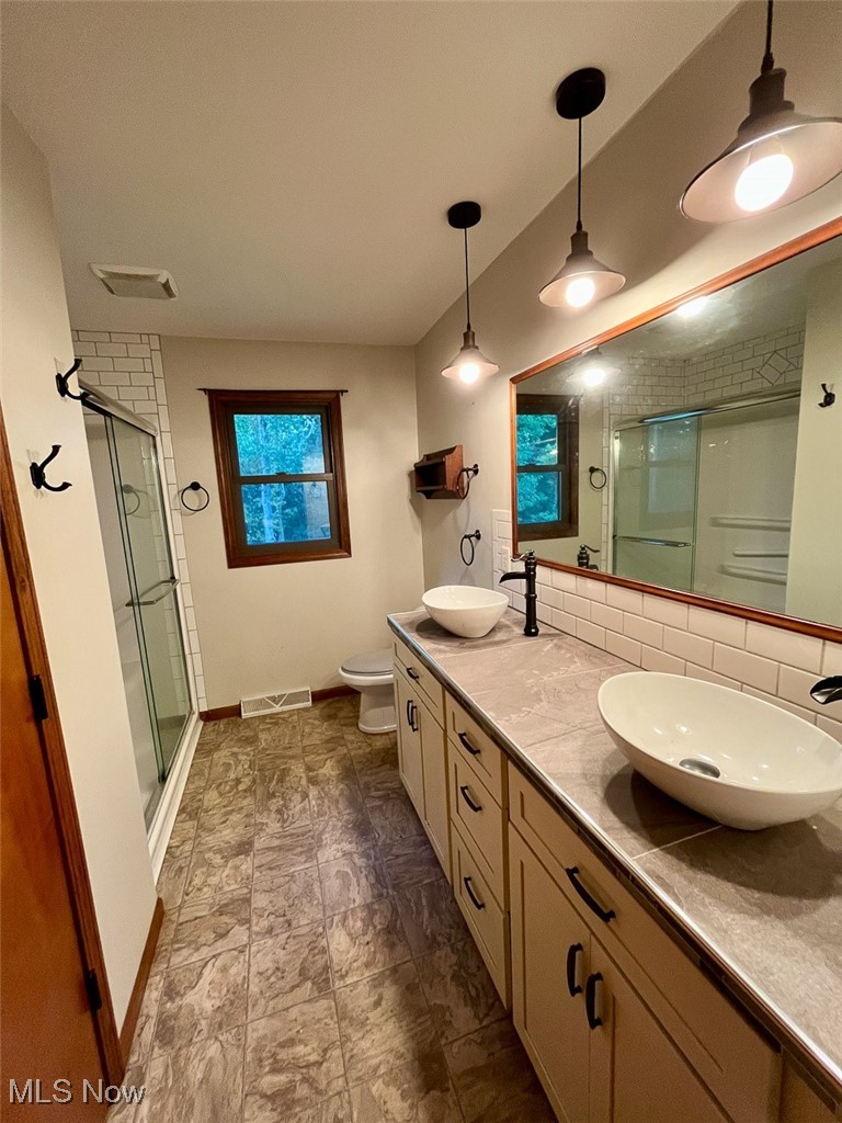 9366 Briar Road Magnolia, OH 44643 - Photo 5 of 25 Full bath featuring double vanity, a shower stall, and decorative backsplash